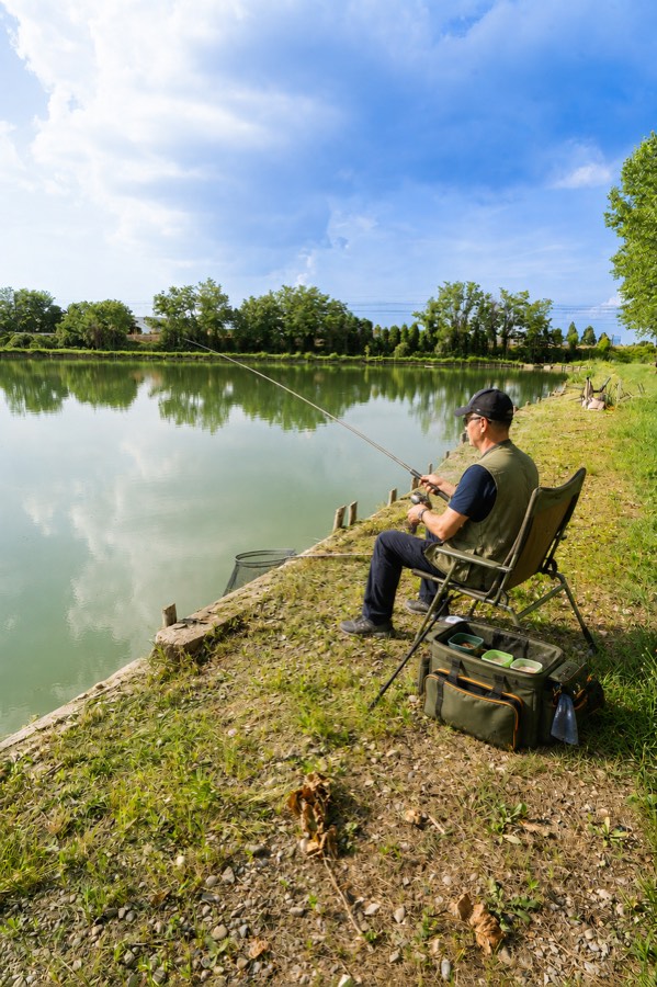 Un pescatore in postazione sulla sponda del lago dei Laghi di Castello