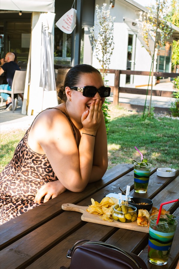 Una ragazza ride durante l'aperitivo in riva al lago