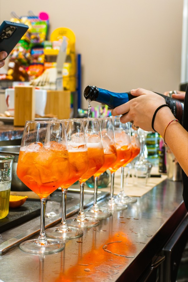 Fila di spritz appena preparati al bar dei Laghi di Castello